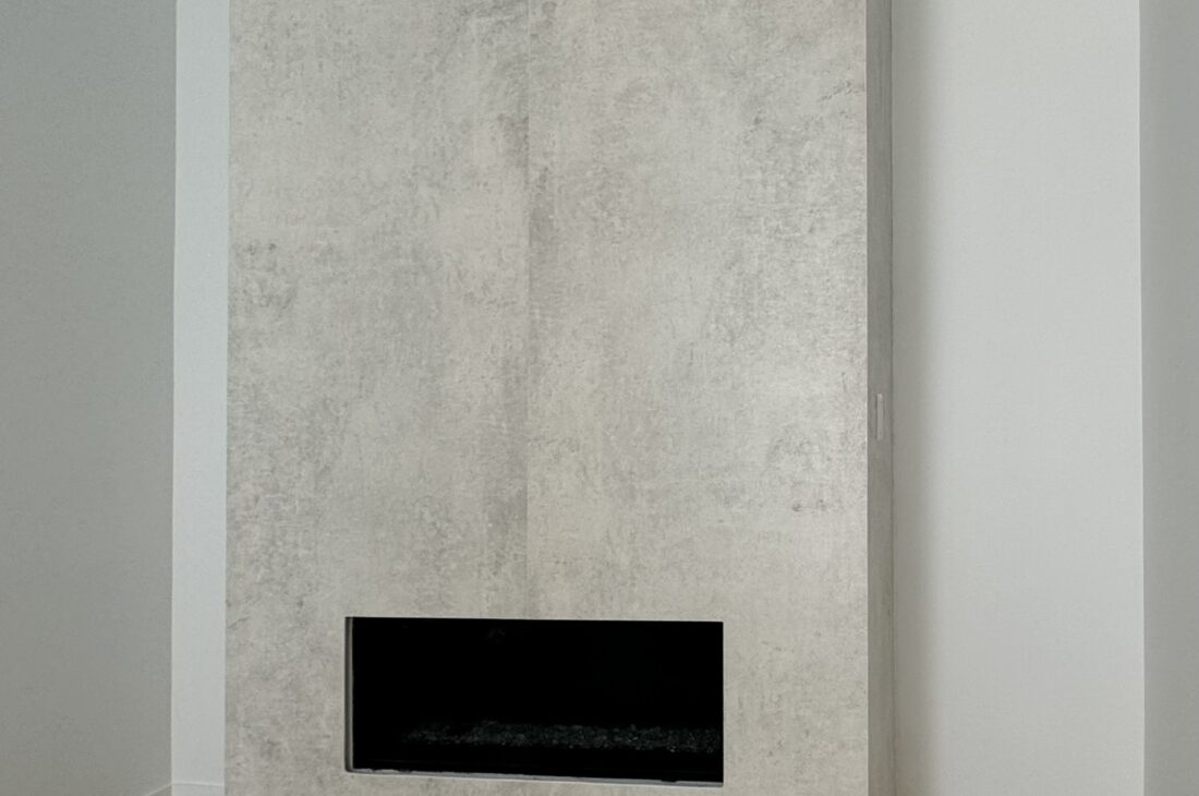 Modern stone fireplace installation in New Westminster and Metro Vancouver including Vancouver, Burnaby, Coquitlam, Surrey, Delta, Maple Ridge, Port Coquitlam, North Vancouver, West Vancouver and Downtown Vancouver. Dekton Lunar fireplace with seamless mitered edges.